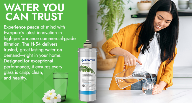Pentair Everpure H-54 water filter next a woman in a yellow jacket during a glass of water from a glass pitcher in her kitchen. Text: Water you can trust